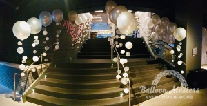 Three railings up staircase are filled by pearl white bubble balloons.