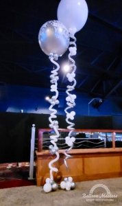 two large silver and white balloons but strings are made of swirly balloons.