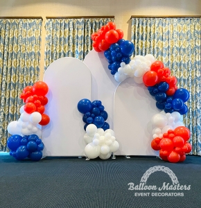 red, white, and blue balloons surrounding 3 white arch backrounds.