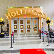 the words "Hollywood" strung above a doorway with black and gold columns on either side of doorway.