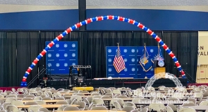 A massive balloon arch over stage made of red blue and white balloons.