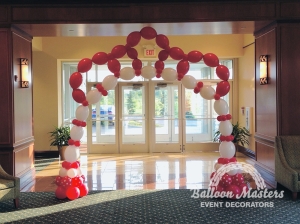 white, and red balloons forming an arch in a large doorway.
