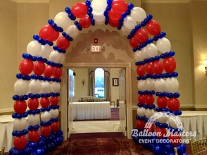 four blue, red, and white balloon arches in front of doorway.