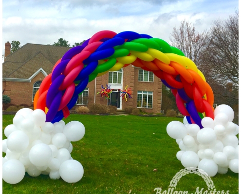 balloon arch resembling a rainbow with clouds.