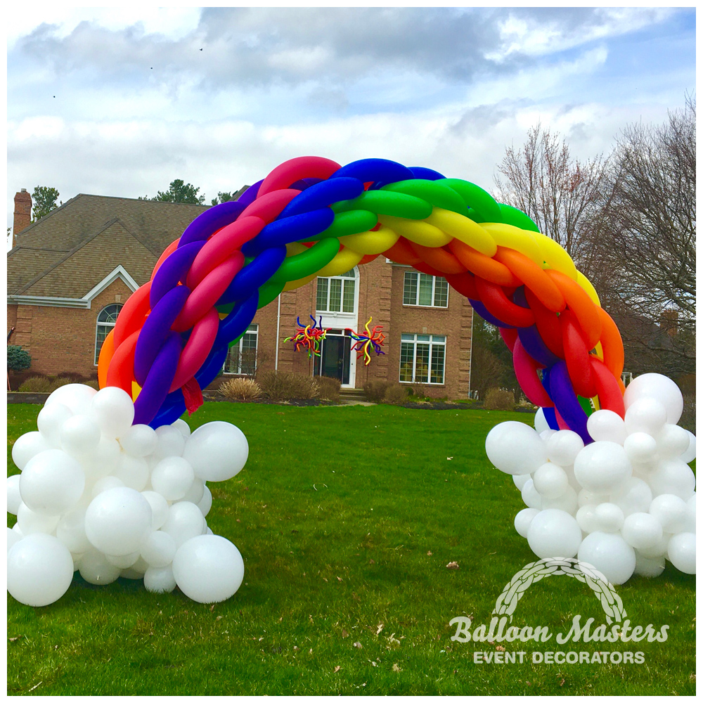 balloon arch resembling a rainbow with clouds.