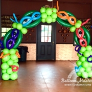 a green balloon arch with the ninja turtles faces built into the arch.
