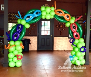 a green balloon arch with the ninja turtles faces built into the arch.