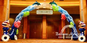 an hombre balloon arch from dark blue to white at peak, with sea creature balloon. animals attached.