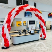 a red and white striped balloon arch.