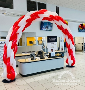 a red and white striped balloon arch.